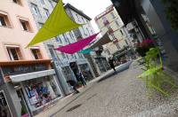 Des velum colorés comme un écho aux tables et chaises de jardin disposées devant les boutiques.