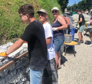 Grazac : des jeunes réalisent un muret en gabion dans le bourg