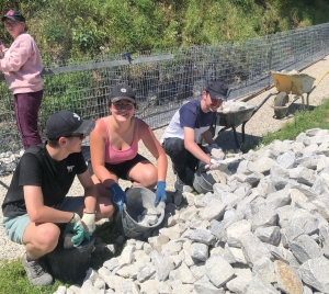 Grazac : des jeunes réalisent un muret en gabion dans le bourg