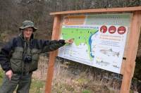 Paul Faurant montre l&#039;un des trois panneaux installés le long du parcours de pêche facile.